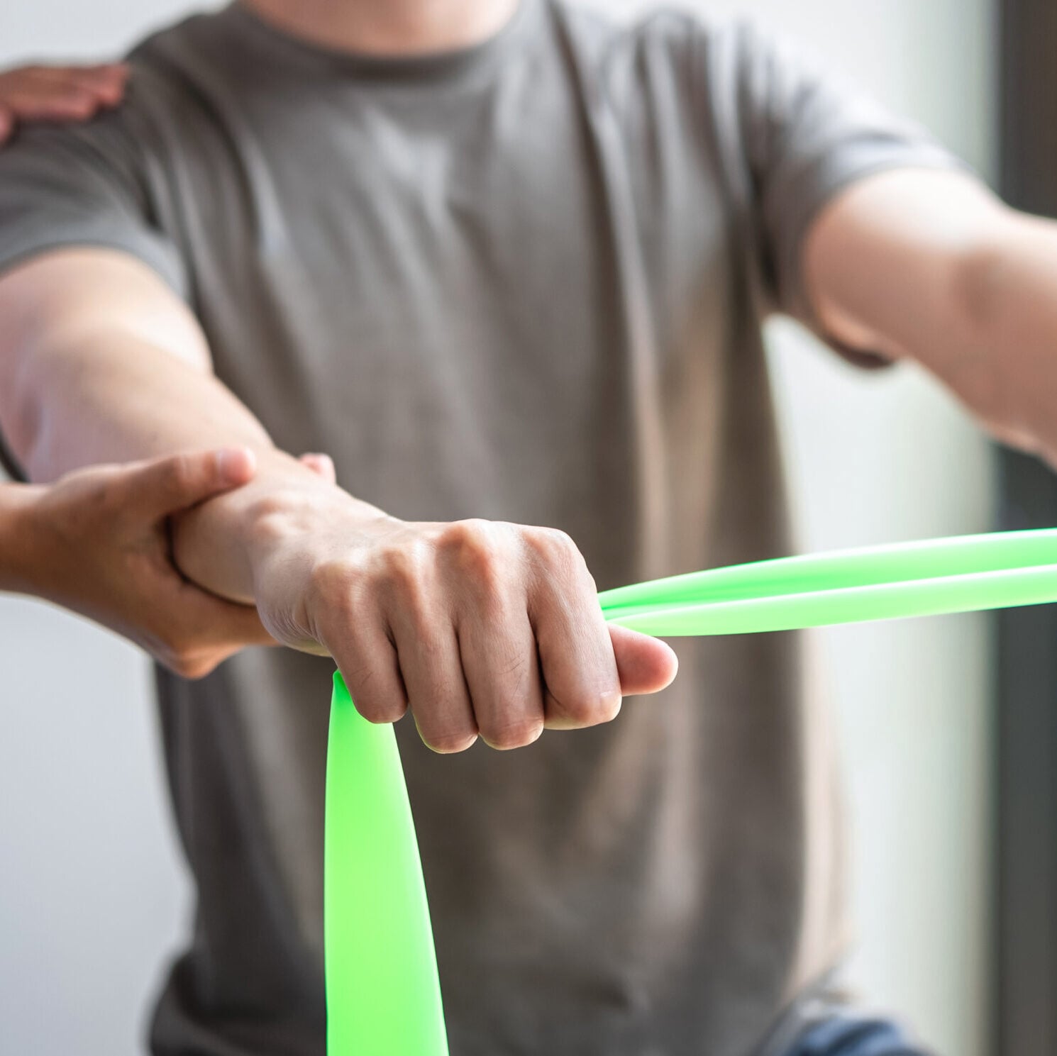 Physical therapist assisting patient with arm band stretches