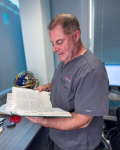 Dr. Packer reading a medical guideline book for documeting impairment